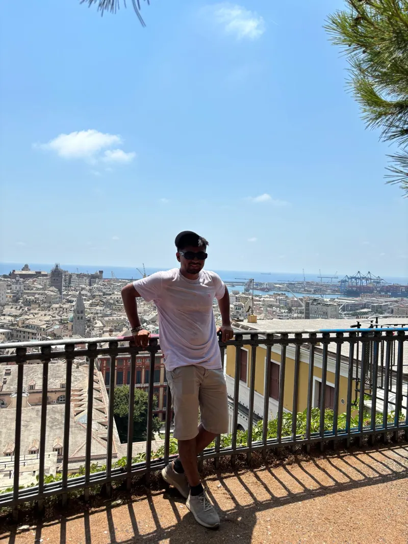 Alex en un mirador de Génova con la ciudad y el puerto detrás