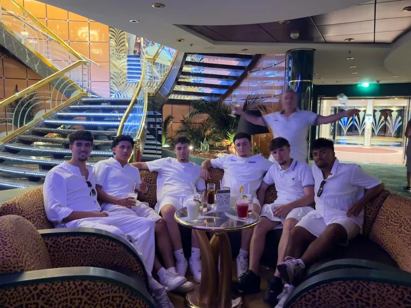 Los amigos vestidos de blanco en el salón del barco